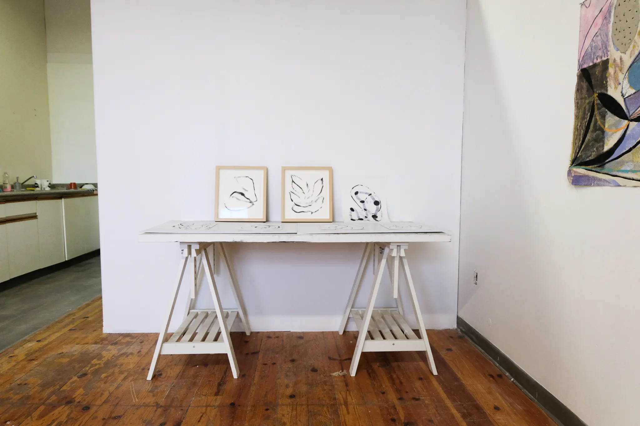 Several works in progress sit atop a table in the studio. 