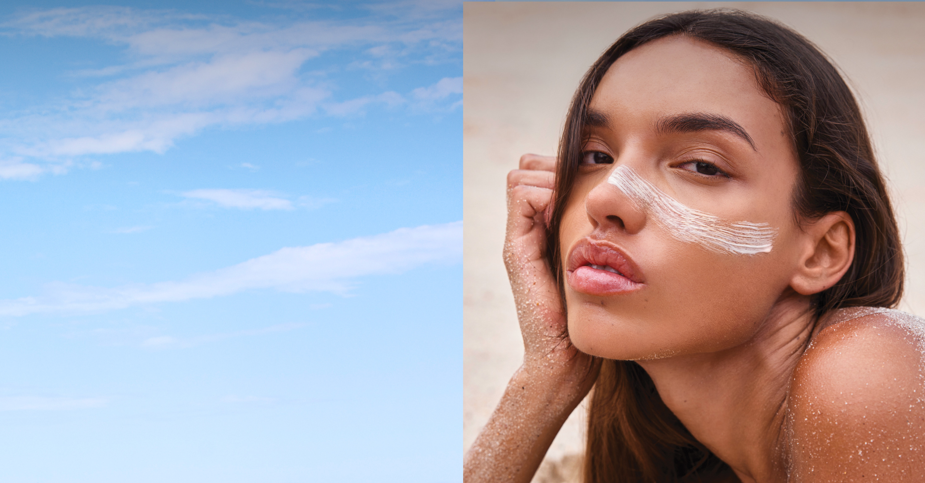 A woman applying sunscreen with a blue sky in the background.