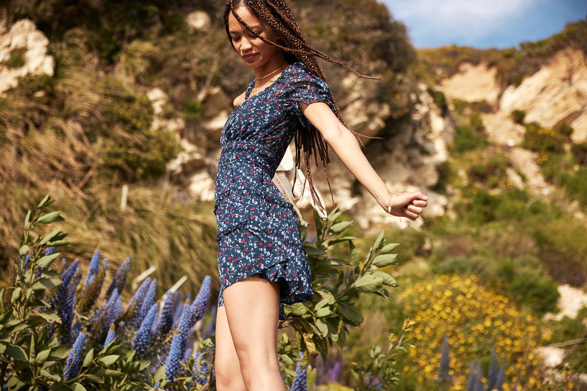 Trixxi sun-kissed summer, girls walking in floral mountain field in navy red floral tier ruffle dress.