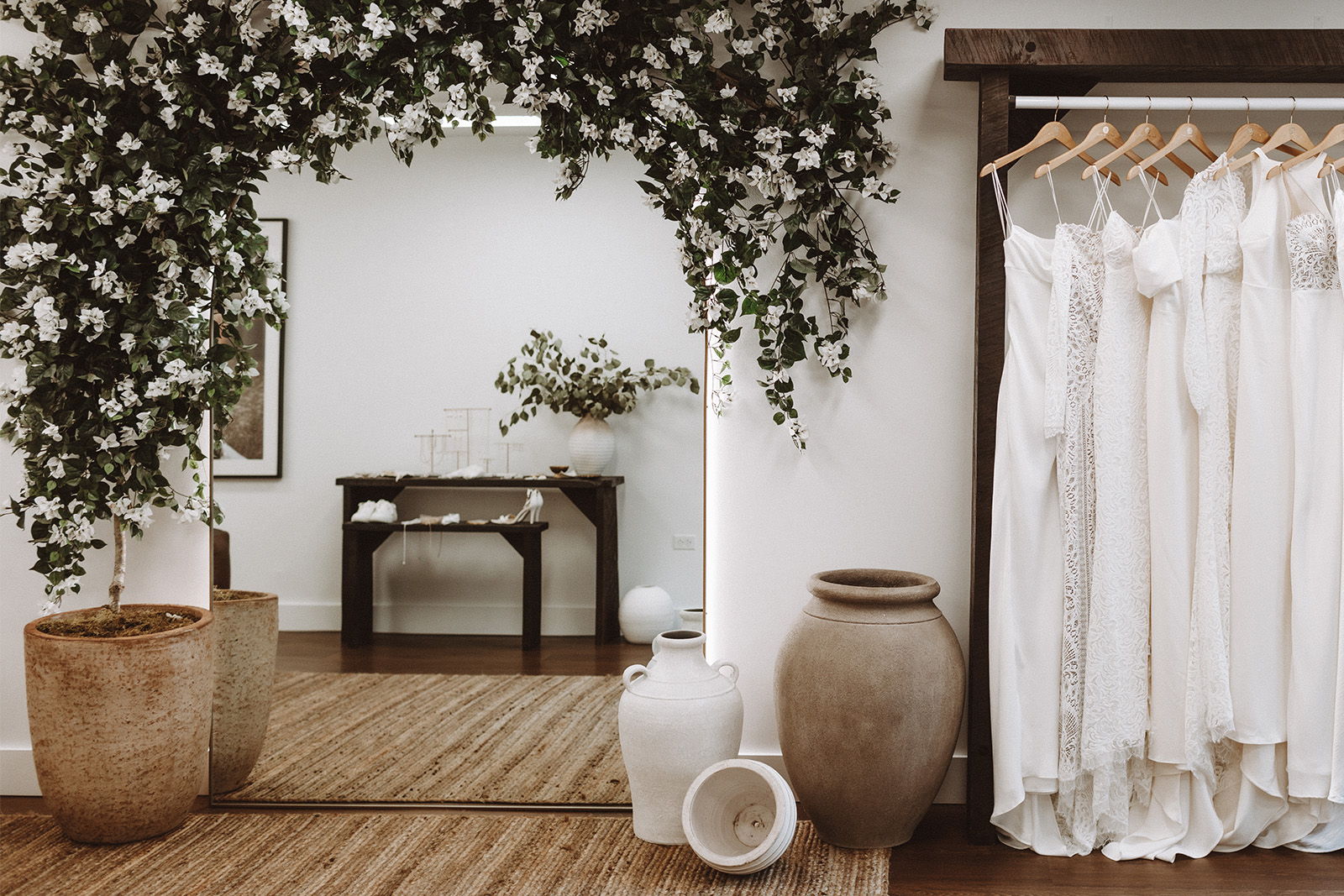 A decorated room showcasing wedding dresses and decorative vases.