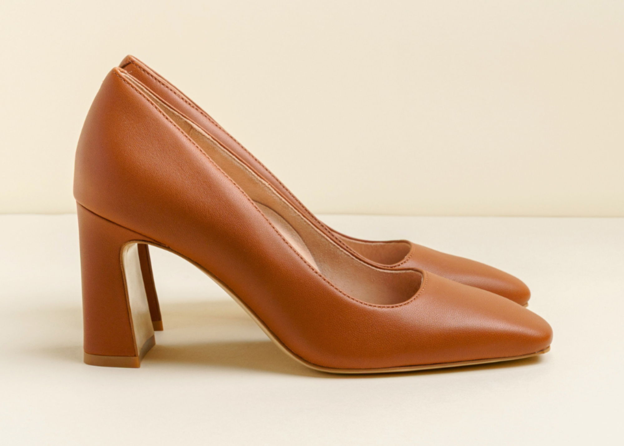 Brown high-heeled shoes on a neutral background.