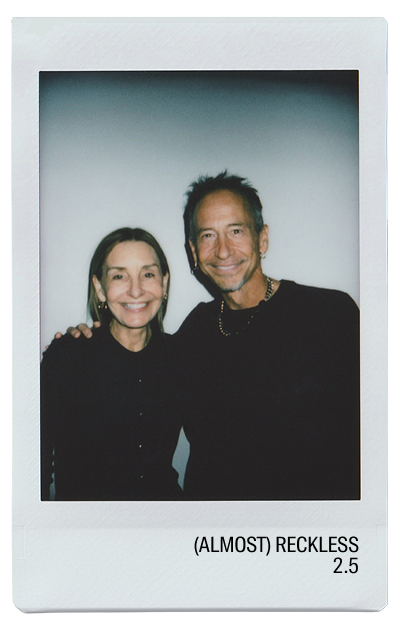 Two smiling individuals posing for a photo with a light background.