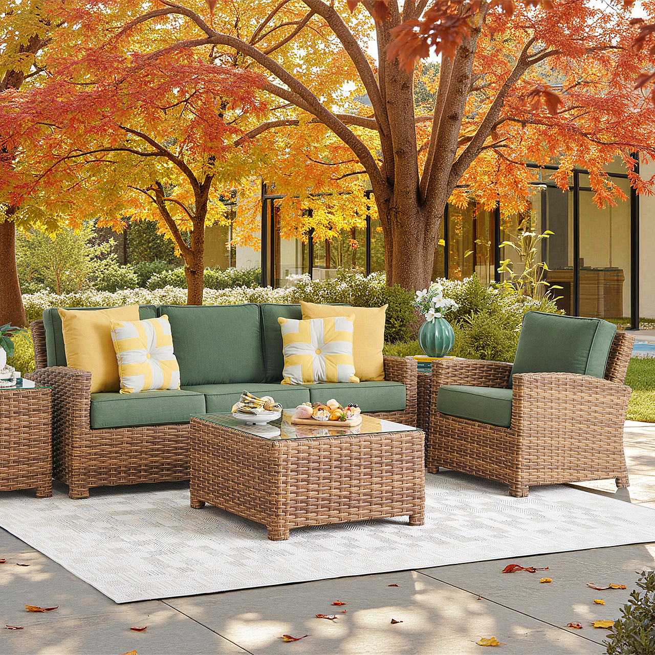 Outdoor seating area with wicker furniture surrounded by fall foliage.