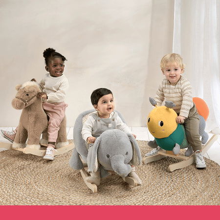 Three children playing on stuffed animal rockers in a cozy setting.
