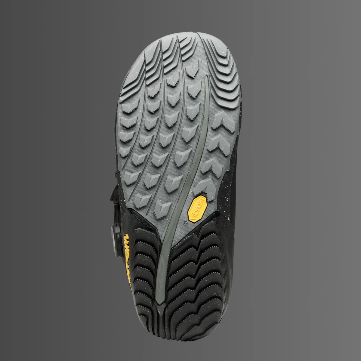 Sole of a shoe with traction pattern and a yellow emblem.