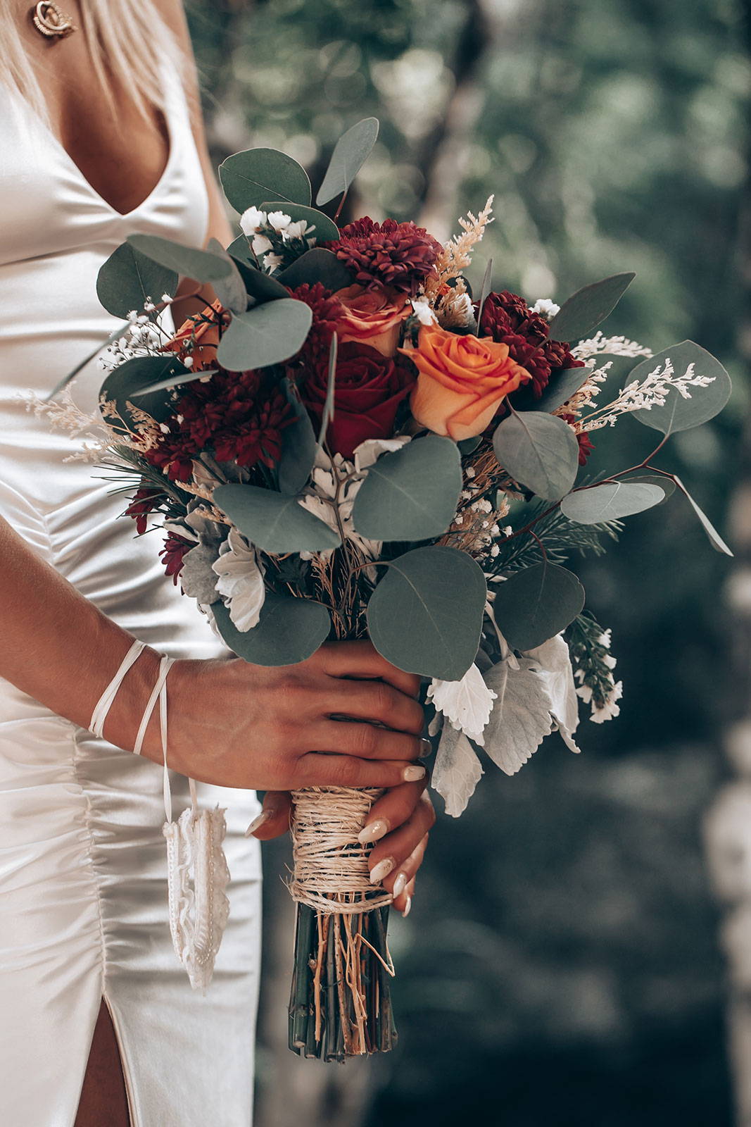 Novia con ramo de flores rojas y naranjas