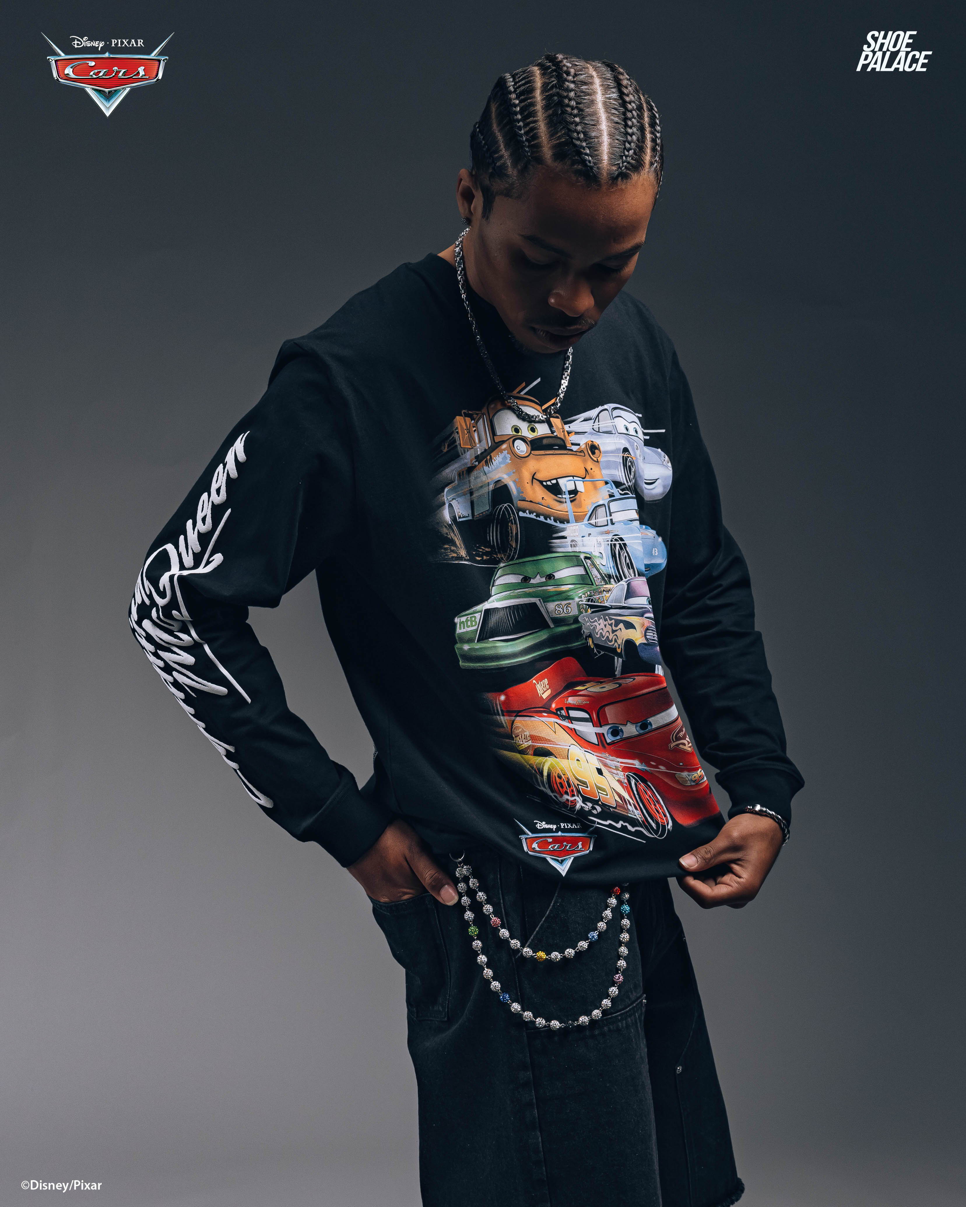 Person wearing a graphic long-sleeve shirt with chains in a studio setting.