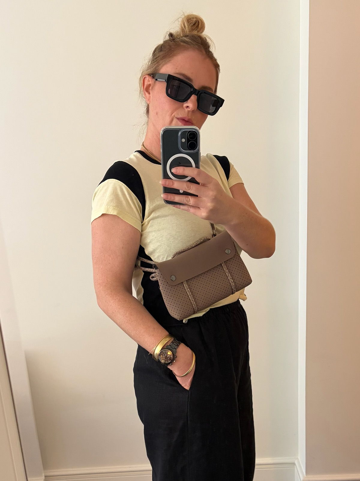 Person taking a mirror selfie, wearing sunglasses and a casual outfit.