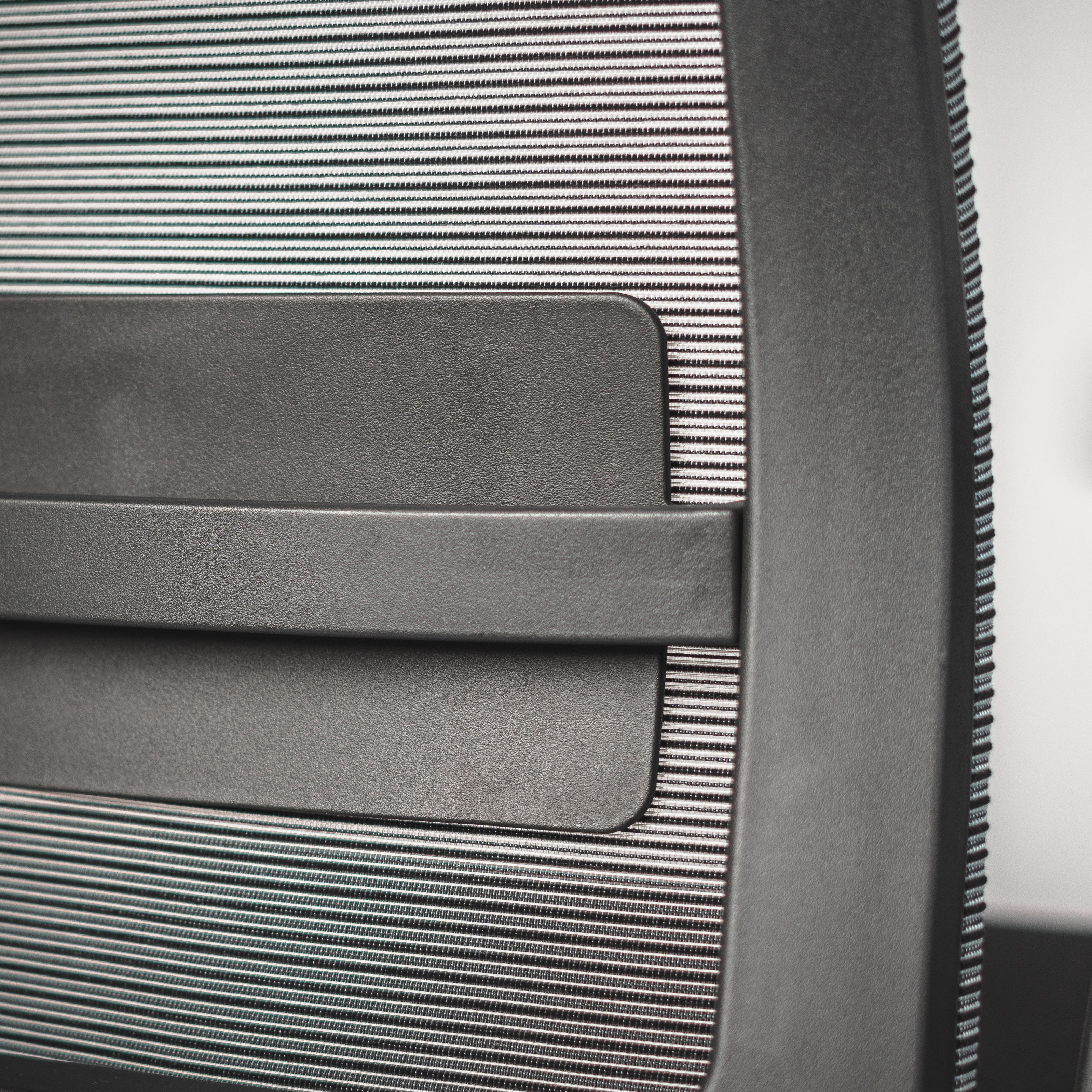 Close-up of the textures and lumbar support on the backrest of the black ergonomic office chair " Active ofinto