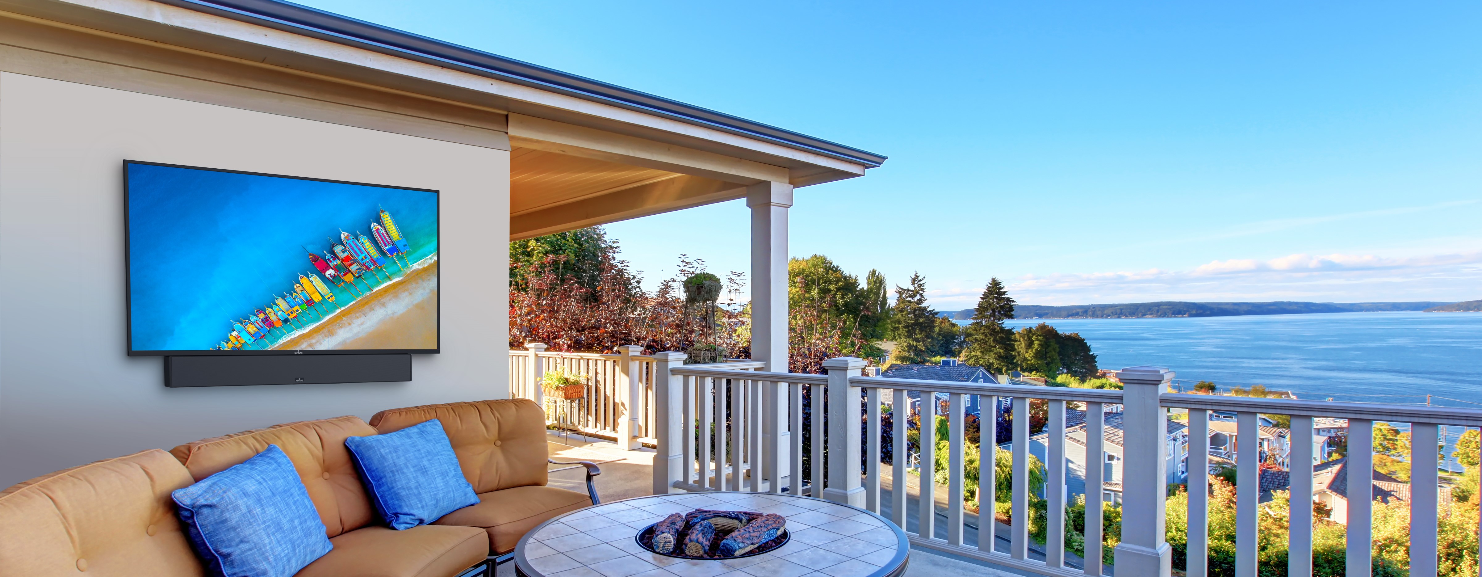 Balcony view with seating, TV, and ocean in the background.