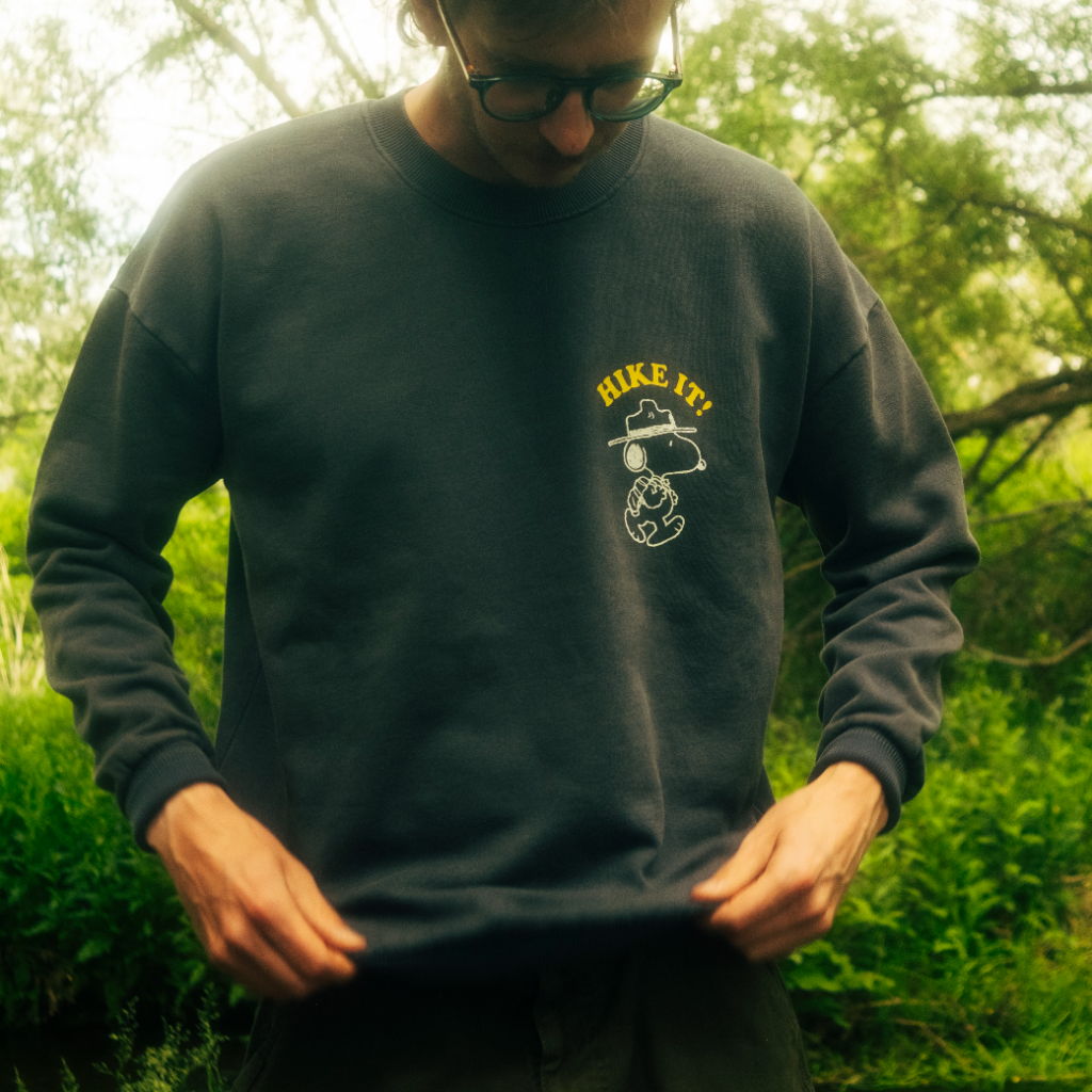 Person wearing a dark sweatshirt in a natural outdoor setting.