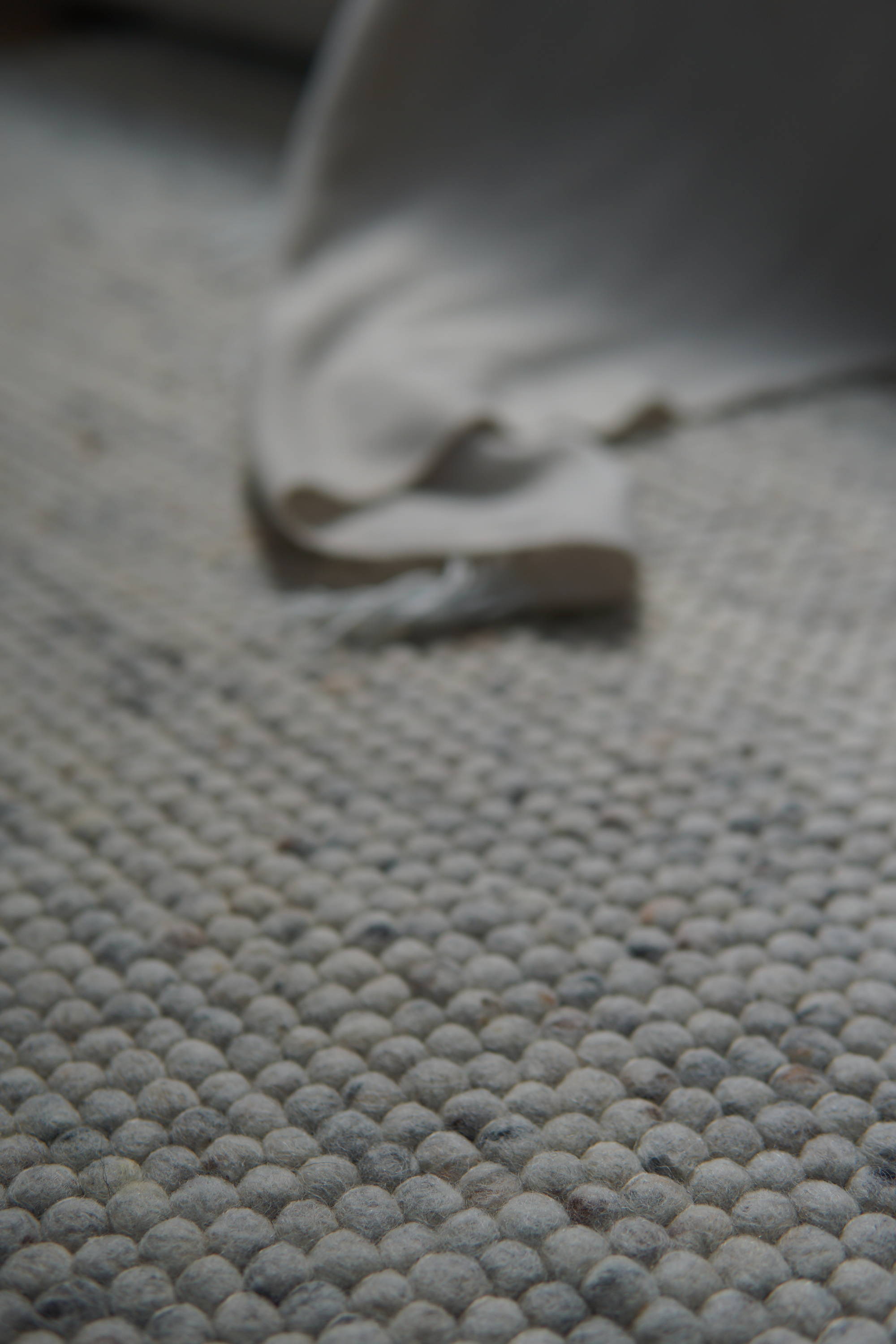 Eine Detailaufnahme eines Teppichs mit einer Decke im Hintergrund