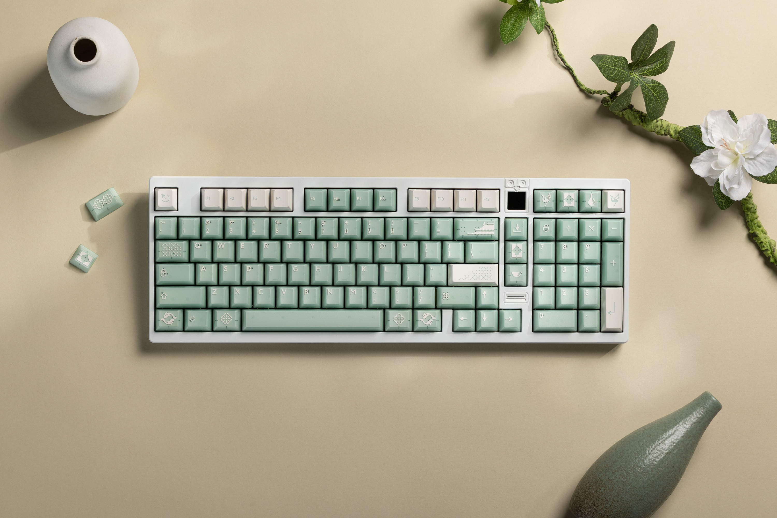 A mint green keyboard on a beige surface with decorative elements.