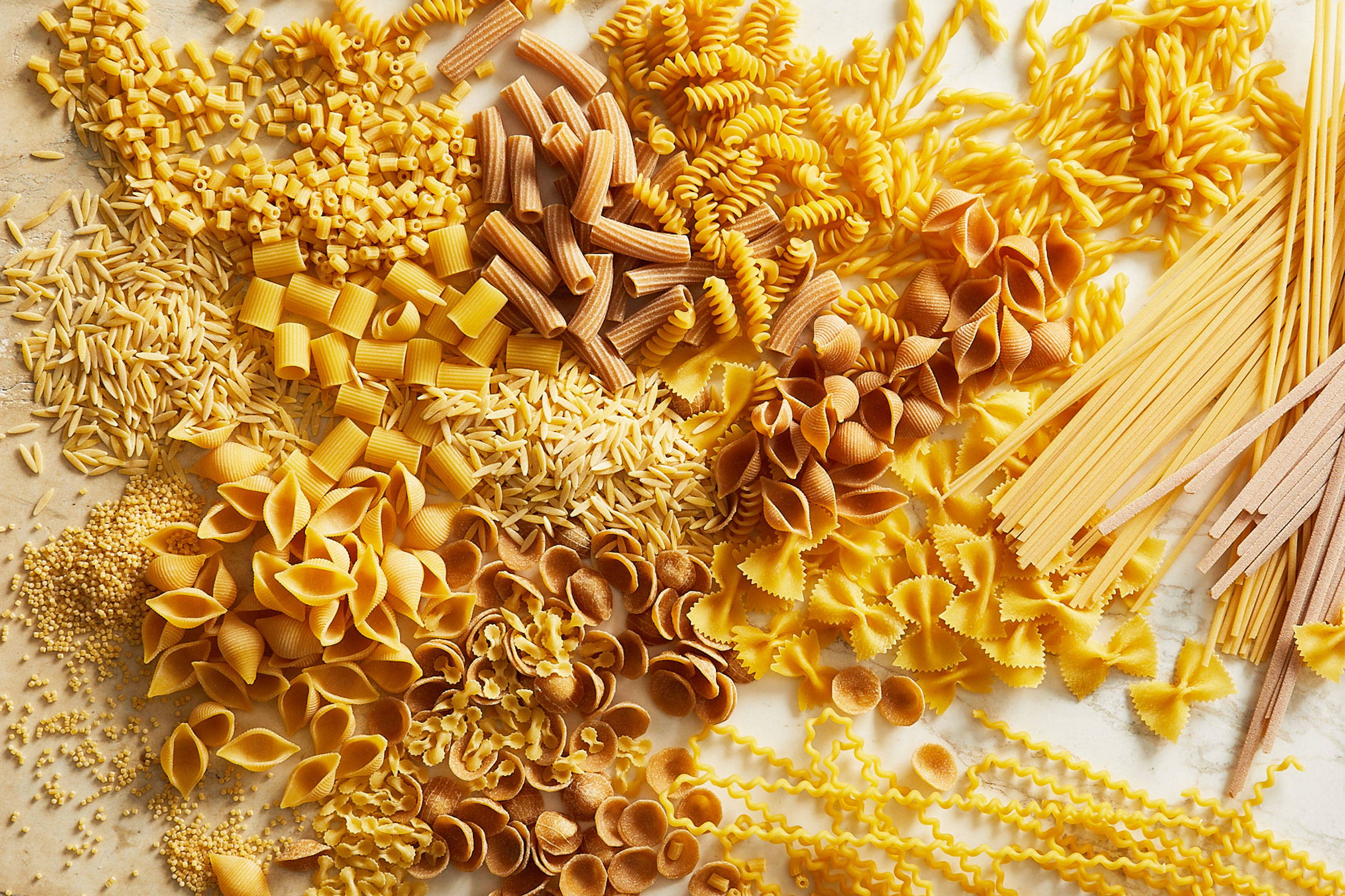 Down shot of assorted cuts of pasta on a table
