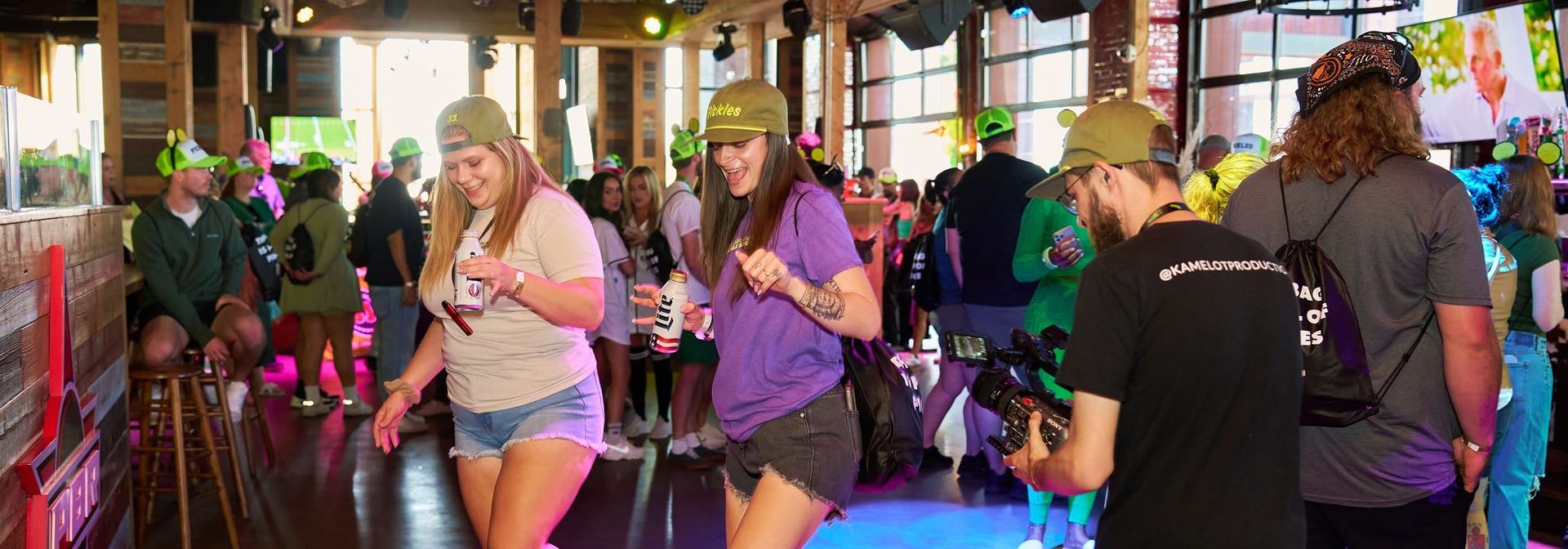 Guests in pickle hats dancing at the VIP party inside PBR Cowboy Bar at The Big Dill pickle festival at Texas Live! in Arlington Texas