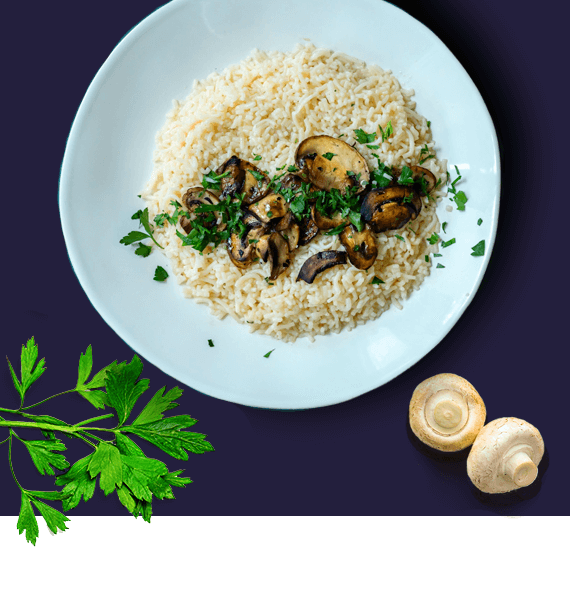 An overhead image of a plate full of It's Skinny rice cooked in simple broth with sauteed mushrooms and parsley.
