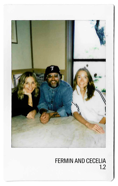 Three people sitting at a table, smiling, with a window in the background.