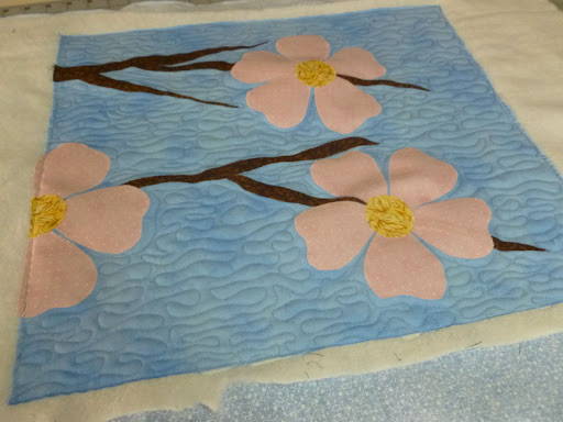 Free Motion Stipple quilting on background and echo quilting on flower petals