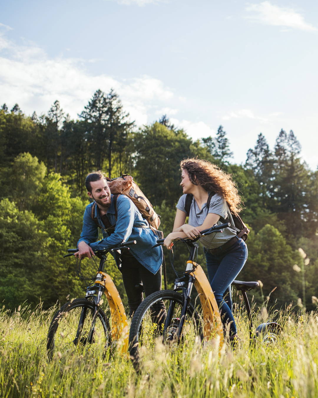 Qu’est-ce qu’une allergie aux graminées? Ce couple fait du vélo dans un pré d’herbes hautes – ils maîtrisent leurs symptômes.