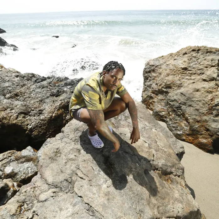 male wearing white crocs on beach