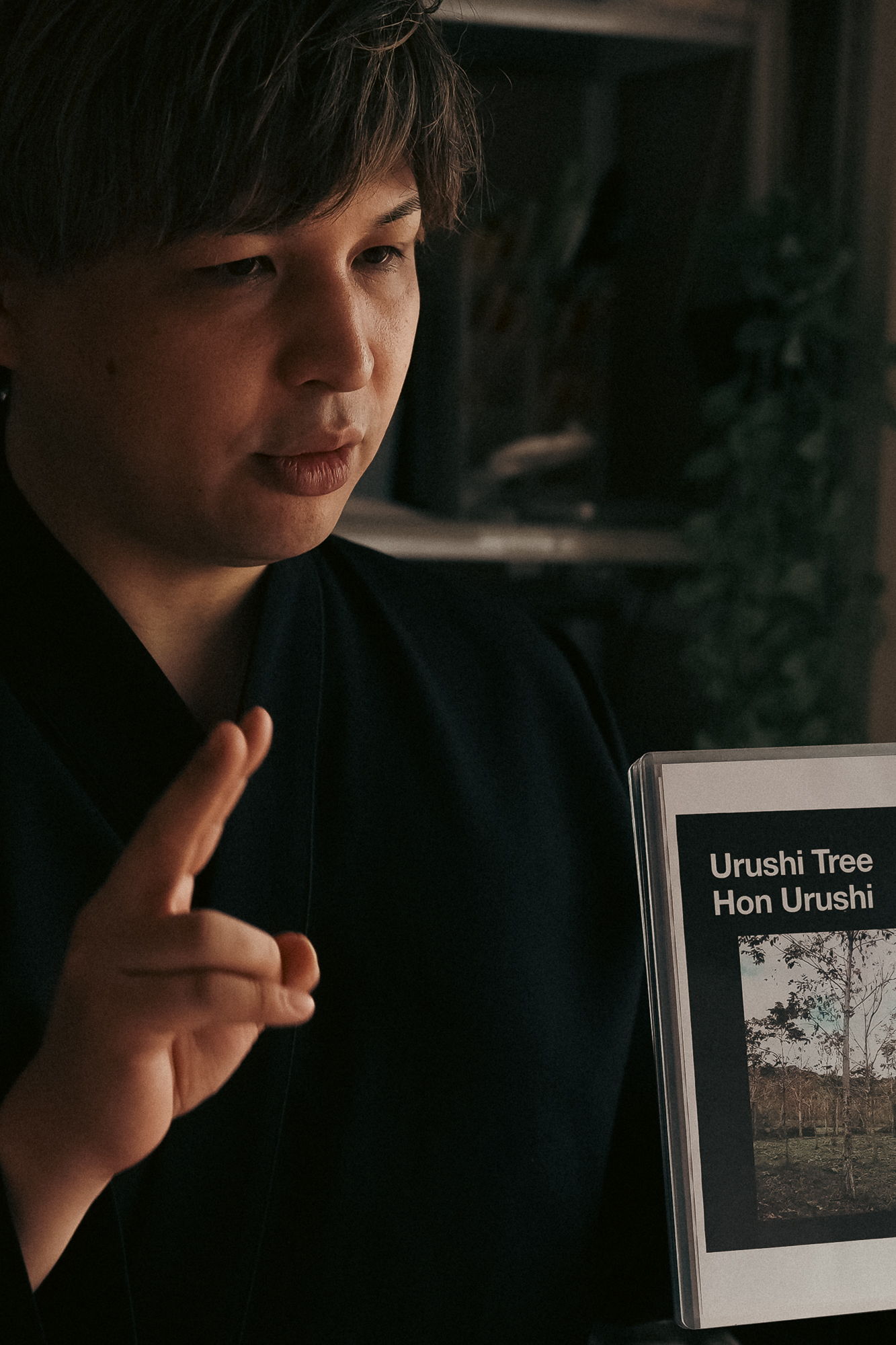 Person in traditional attire holding a book titled 
