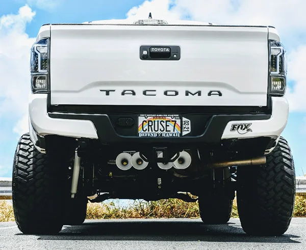 Rear low-angle white Tacoma four train horns under chassis CRUSE7 DEFEND HAWAII FOX sticker Christian's 232 gallery photo 2