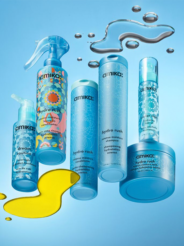 Collection of blue cosmetic products against a light blue background with water droplets.