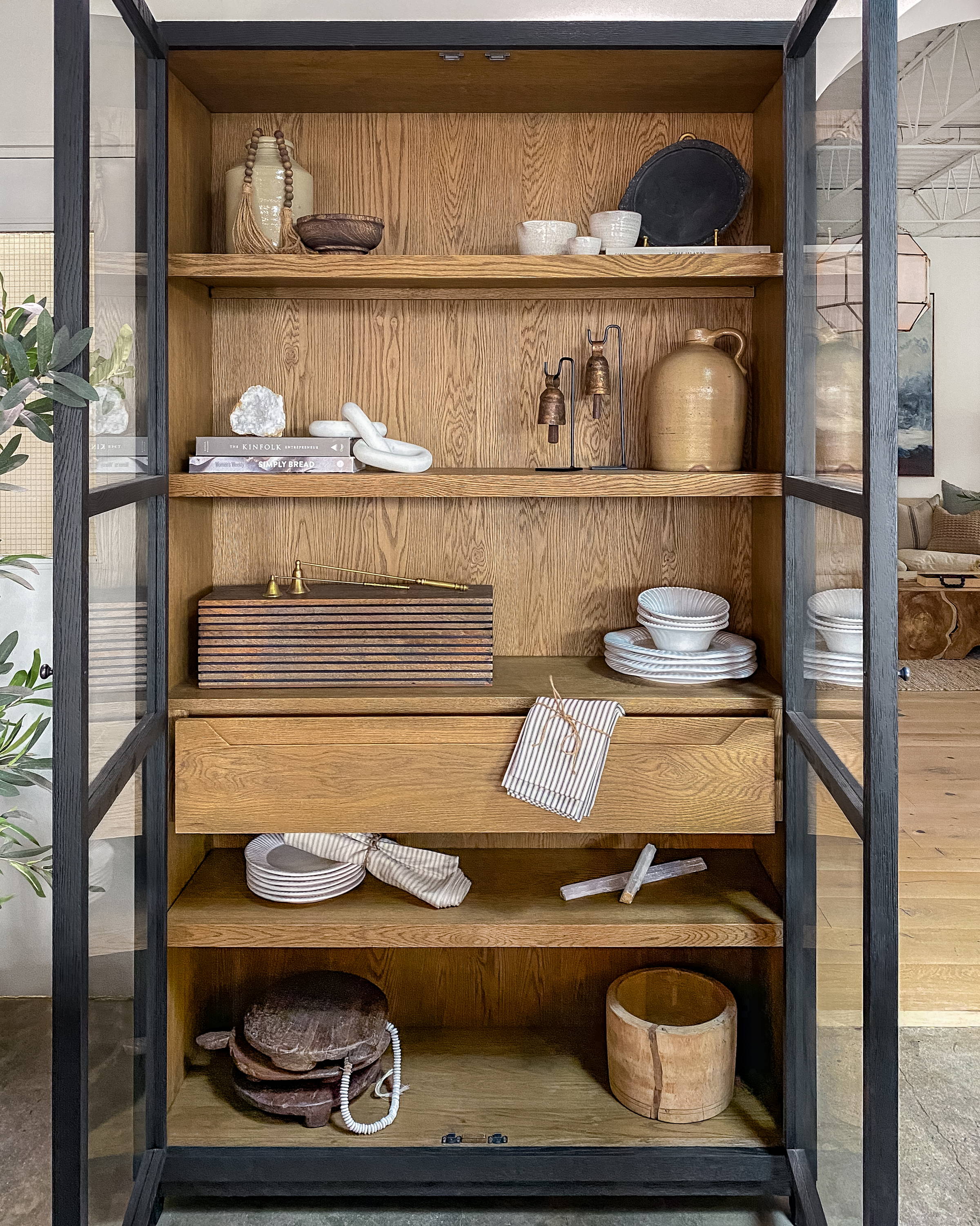Black and oak wood display cabinet with decorative object styling.