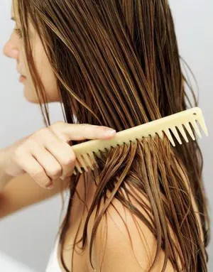 Girl brushing wet hair with comb