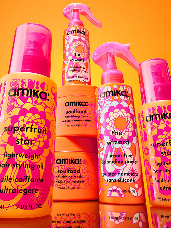 Colorful hair care products on a vibrant orange background.
