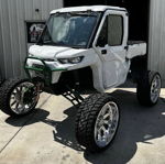 Front three-quarter white Can-Am Defender dark green lift kit chrome wheels brush guard XLR8 shop Rich's Conductor's Special 244K Spare Tire Delete featured gallery photo 1