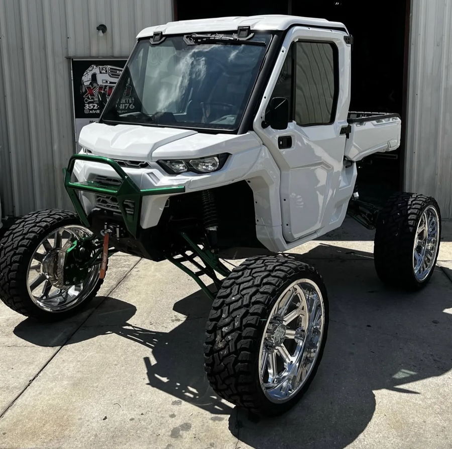 Front three-quarter white Can-Am Defender dark green lift kit chrome wheels brush guard XLR8 shop Rich's Conductor's Special 244K Spare Tire Delete featured gallery photo 1