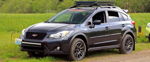 Front three-quarter dark gray Subaru Crosstrek mesh grille red emblem roof cargo basket LED light bar STRLORD plate dirt path Byron's Nathan AirChime K5 Premium featured gallery photo 1