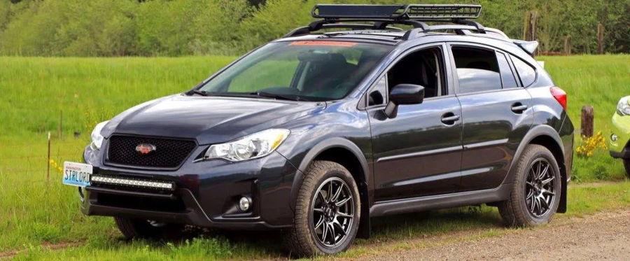 Front three-quarter dark gray Subaru Crosstrek mesh grille red emblem roof cargo basket LED light bar STRLORD plate dirt path Byron's Nathan AirChime K5 Premium featured gallery photo 1