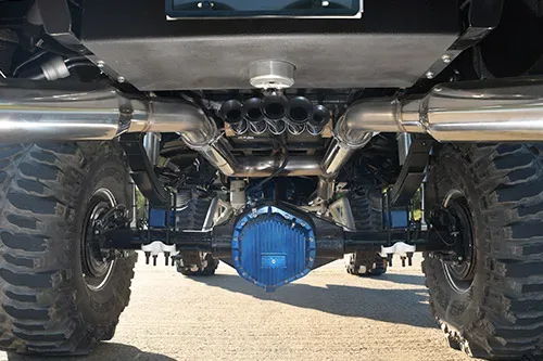 Train horn kit and air tank mounted under a truck near a blue differential cover