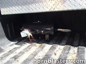Black air tank mounted beneath truck bed toolbox