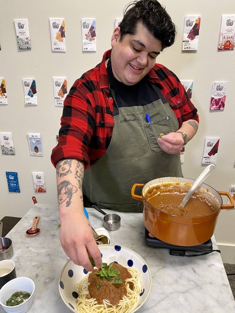 Andrew plating his chocolate pasta sauce on a bowl of spaghetti