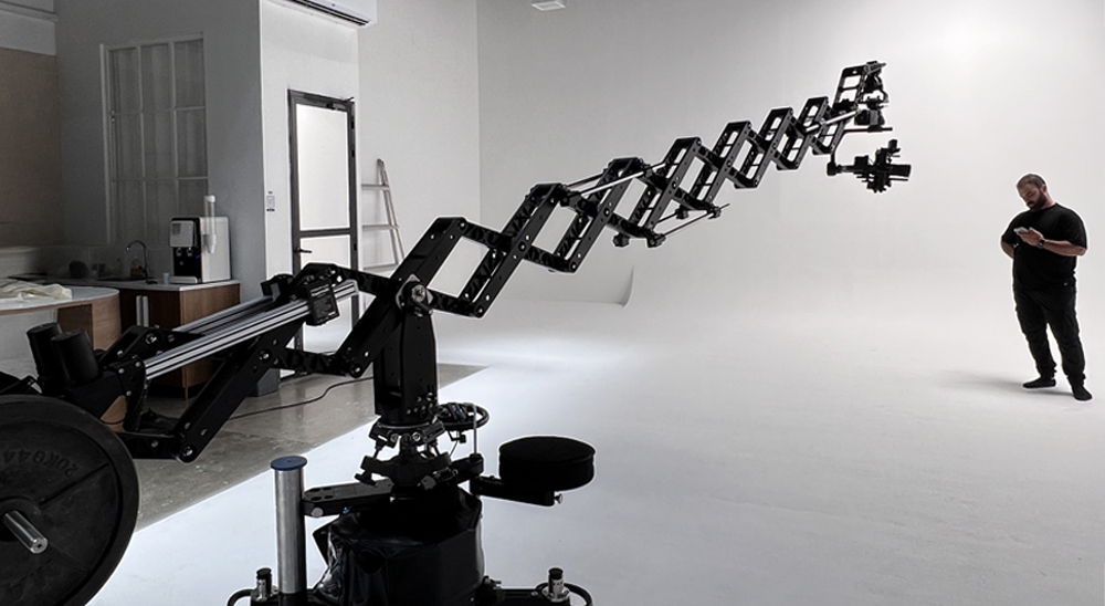 A person operating a camera crane in a studio setting.