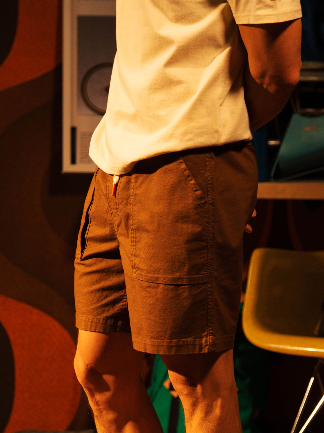 Person wearing a white shirt and brown shorts, seen from behind.