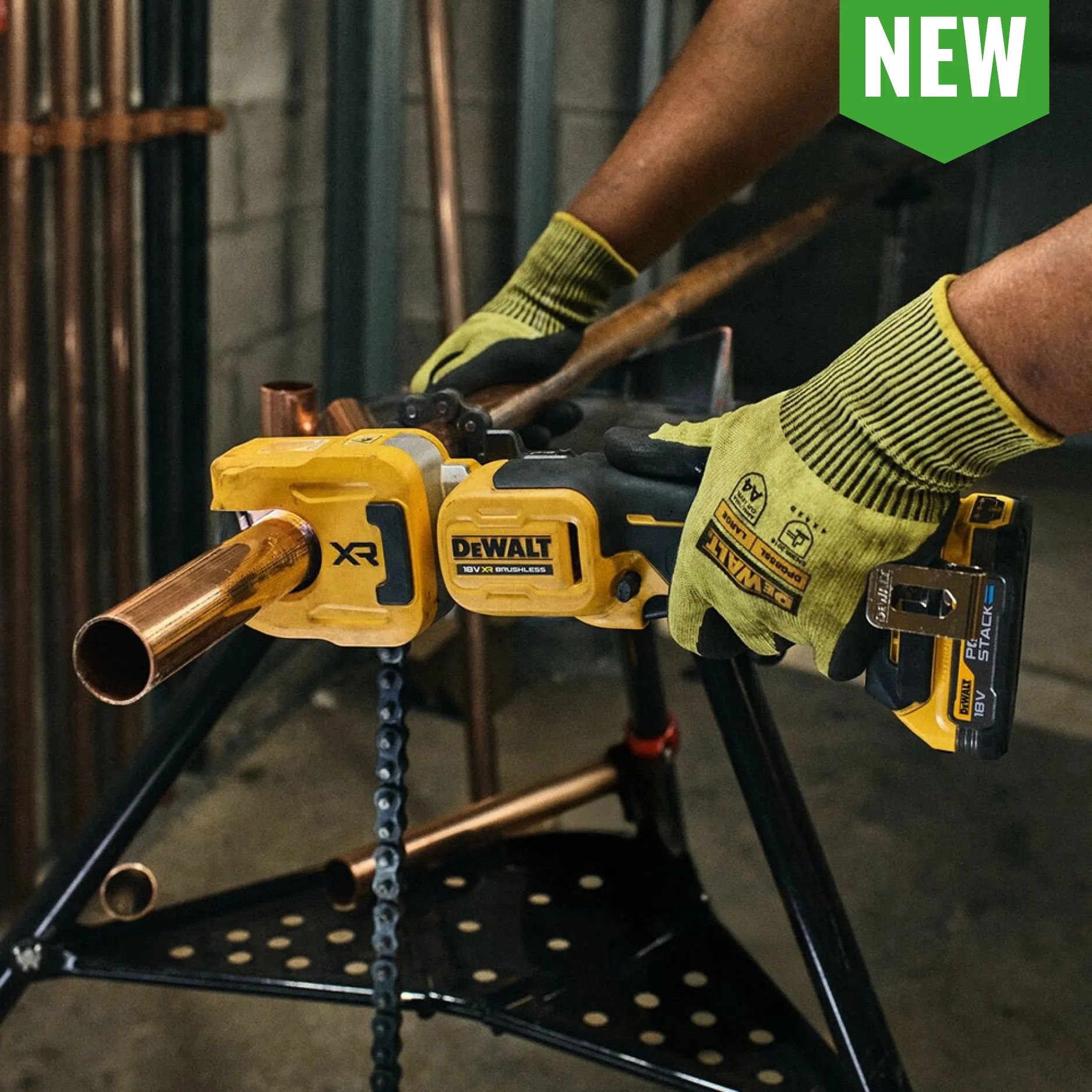 Person using a yellow DEWALT tool on a copper pipe.