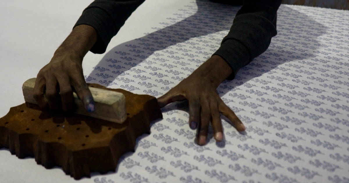 Man block printing a textile
