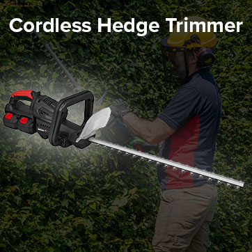 Cordless hedge trimmer in use near a bush.