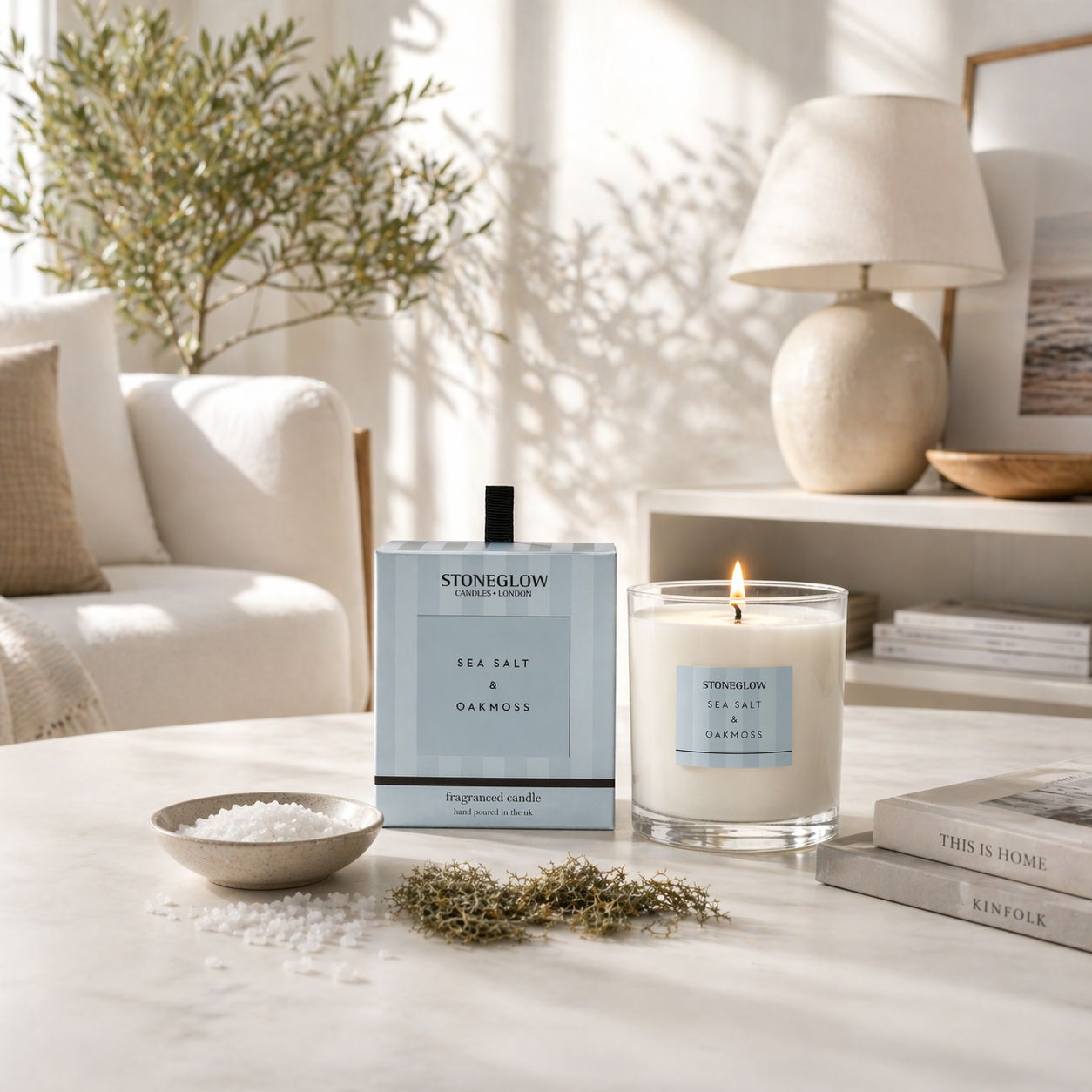 A cozy living room with a candle and a fragrance bottle on a table.