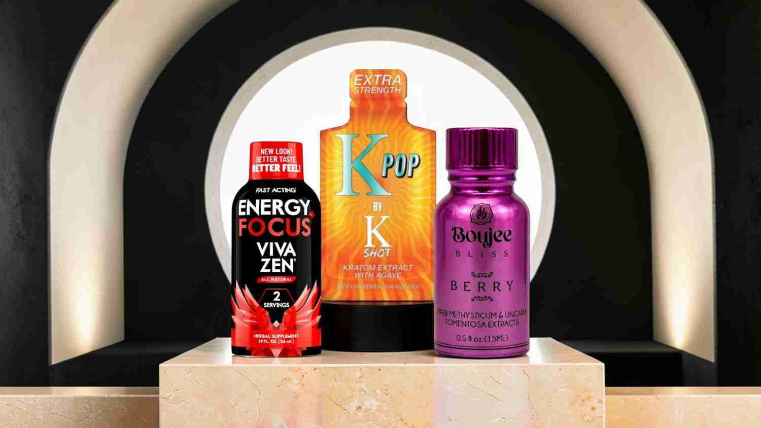 Three energy drink bottles displayed on a pedestal with an arch background.