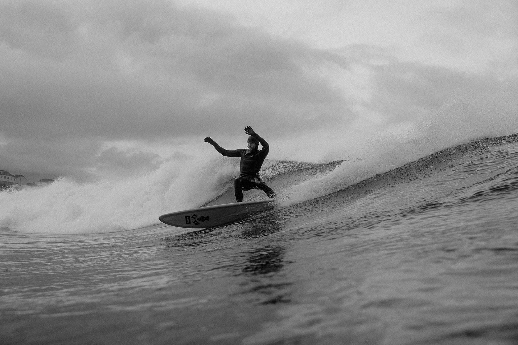 Surfer riding a wave in black and white.