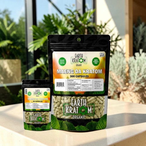 Bags of kratom capsules on a table with greenery in the background.