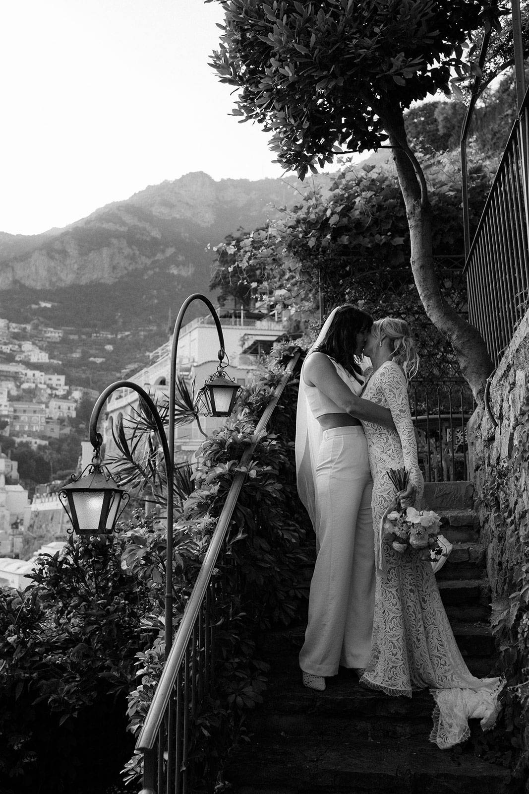 Brides sharing a kiss on an old, concrete staircase
