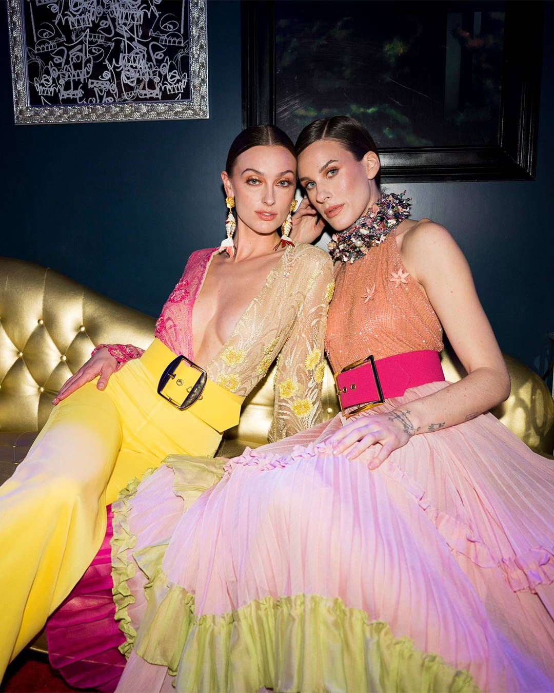 Image of 2 models posing in colorful eccentric outfits