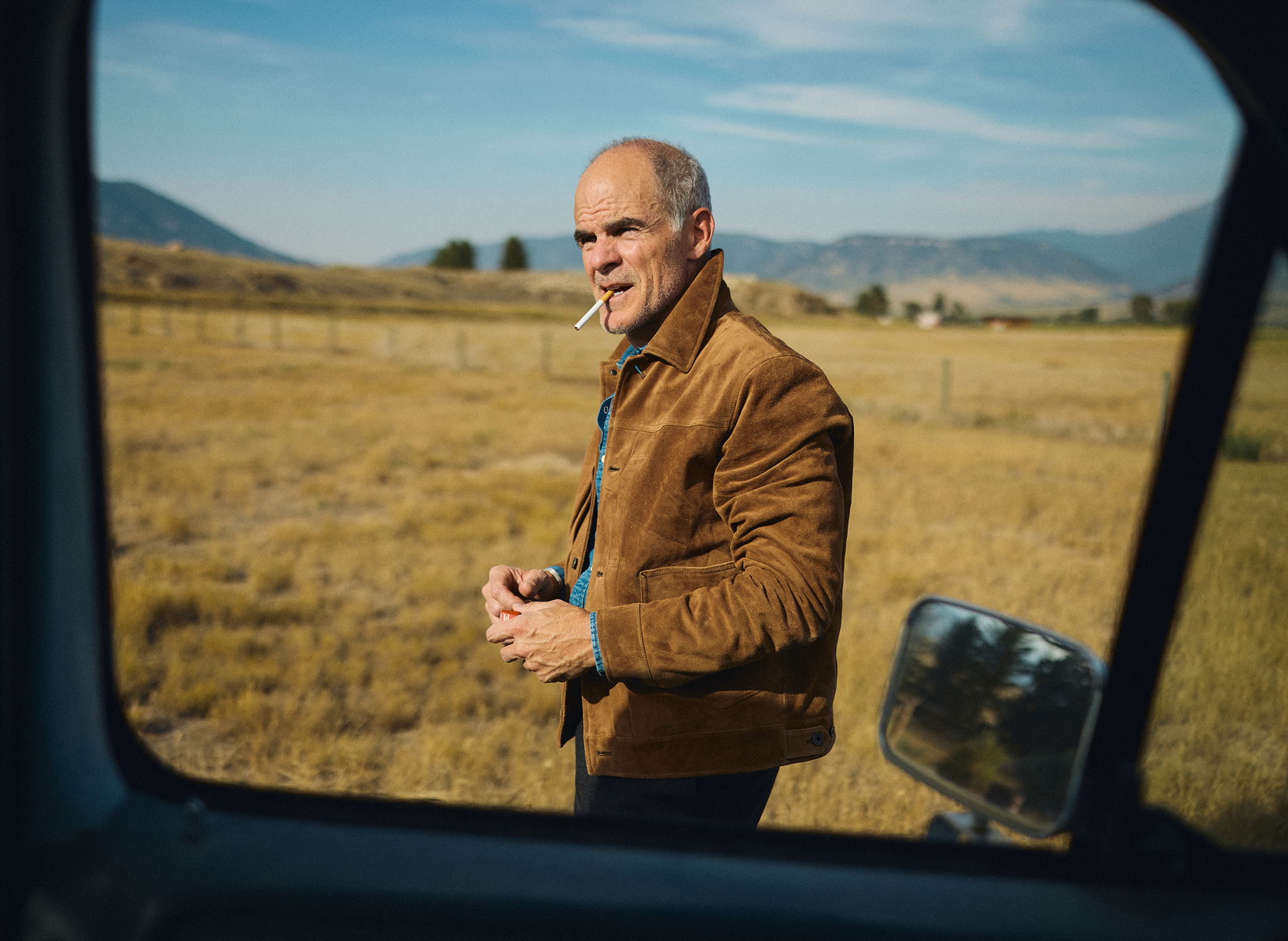 Michael Kelly shot through the window of an old blue ford pickup wearing the Townes Italian Suede Type II Jacket