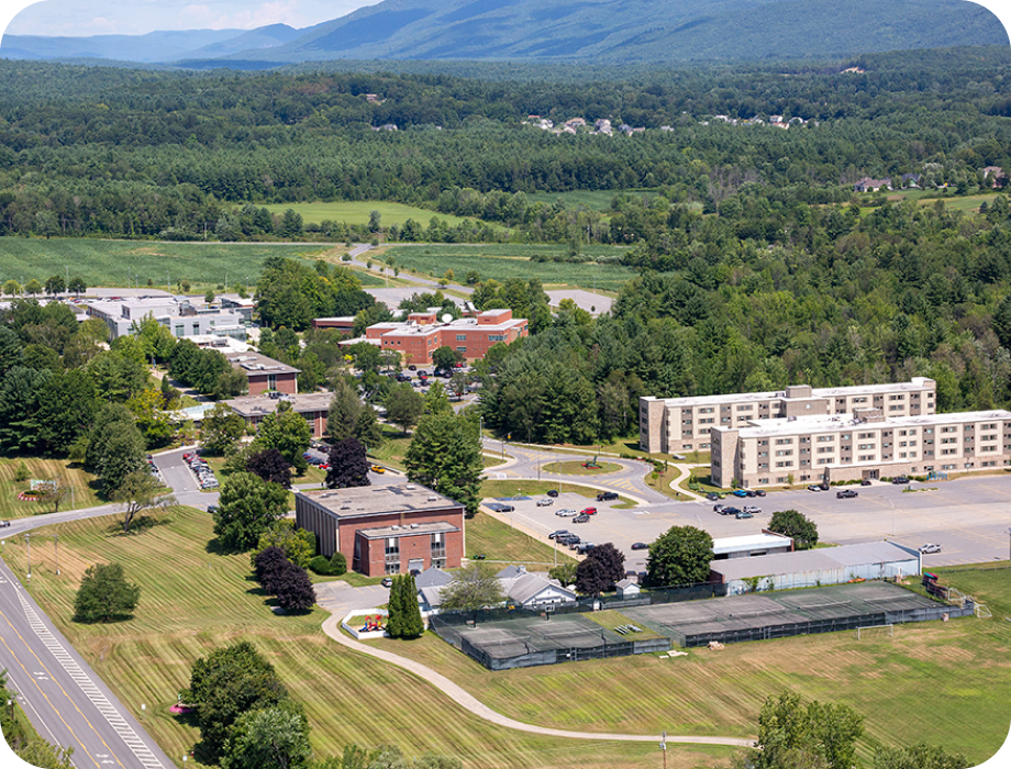 Aerial view of a small town surrounded by mountains and open fields.